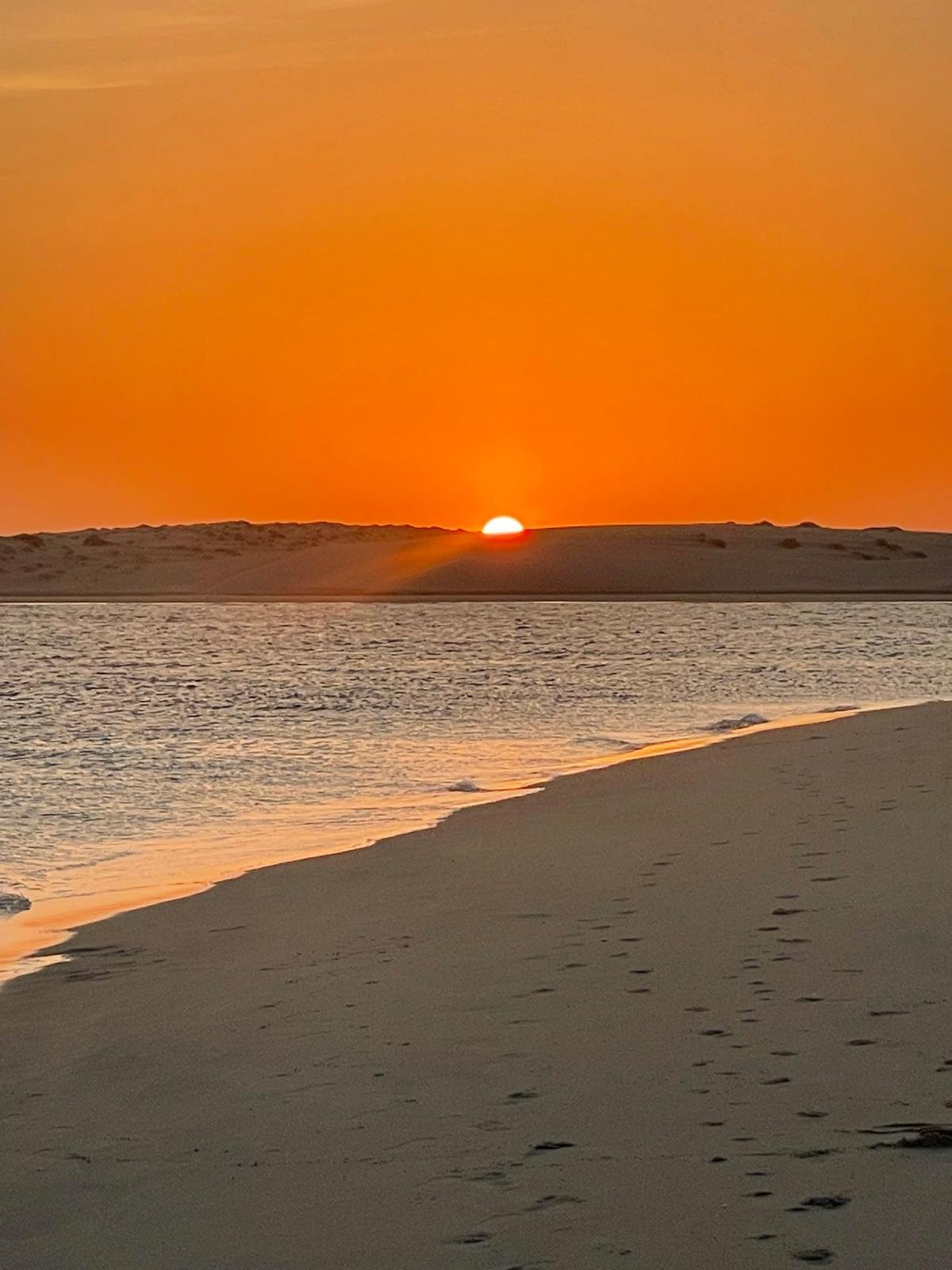 The sun setting over the dunes at Sealine