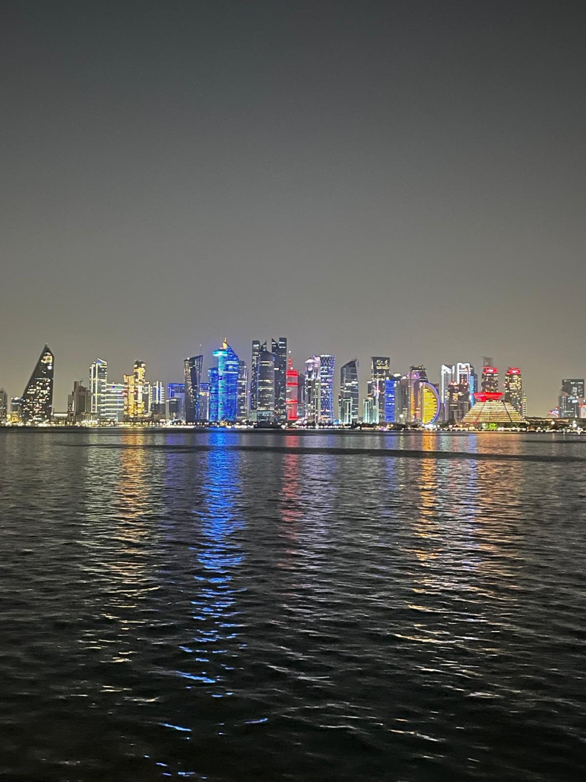 The Doha skyline lit at night across the bay